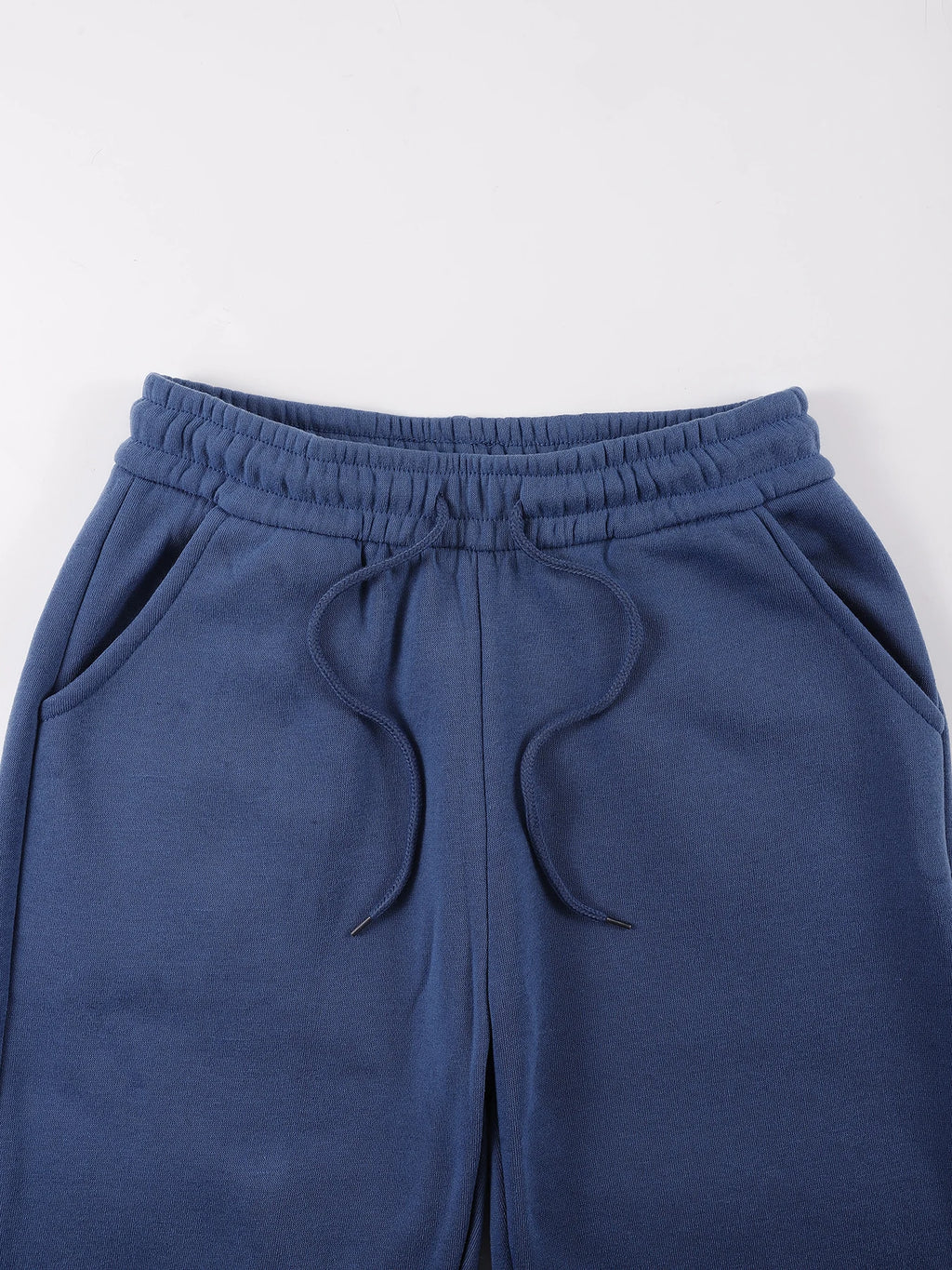 Es un conjunto de dos piezas compuesto por una sudadera con capucha y pantalones deportivos.