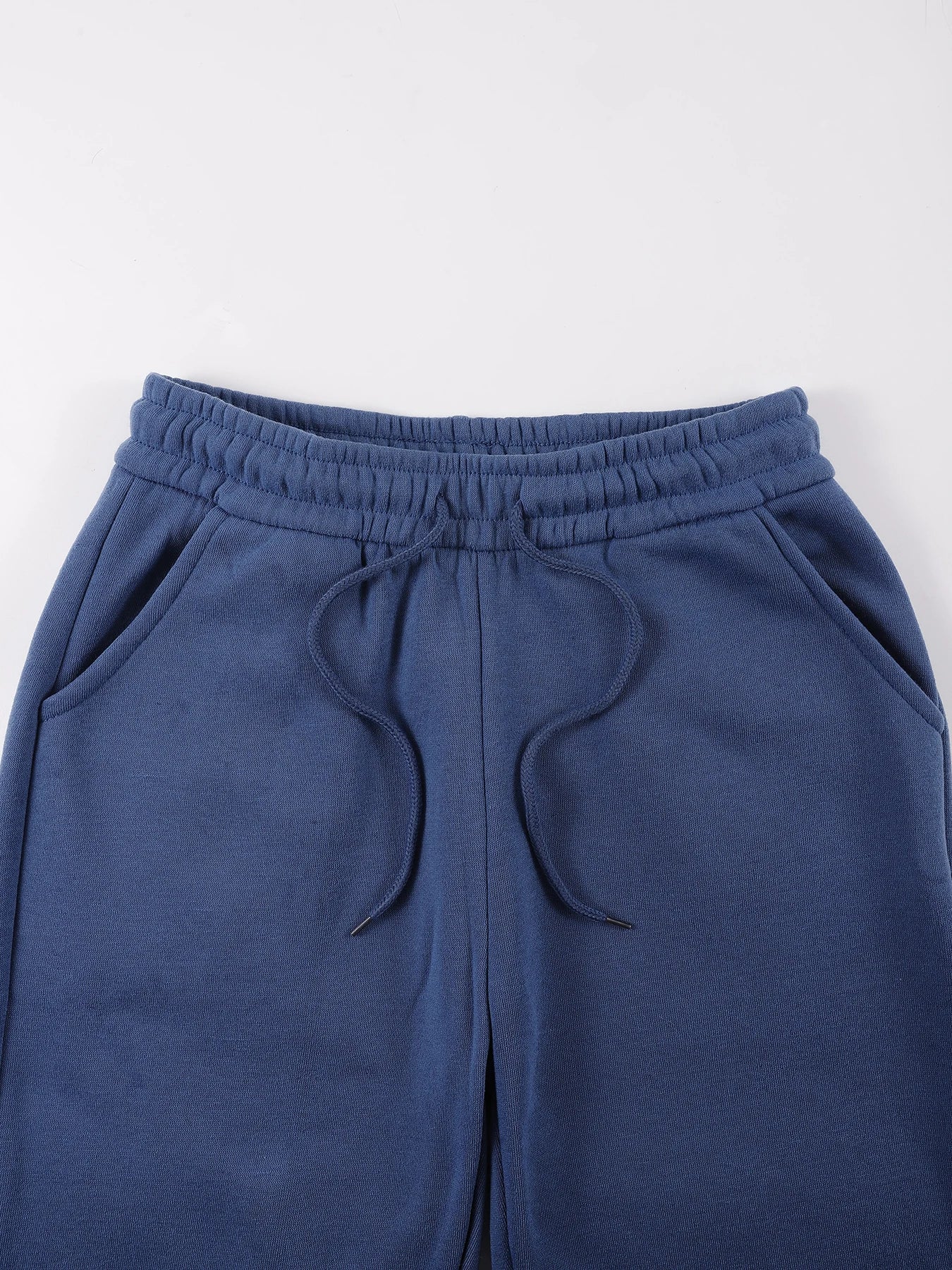 Es un conjunto de dos piezas compuesto por una sudadera con capucha y pantalones deportivos.