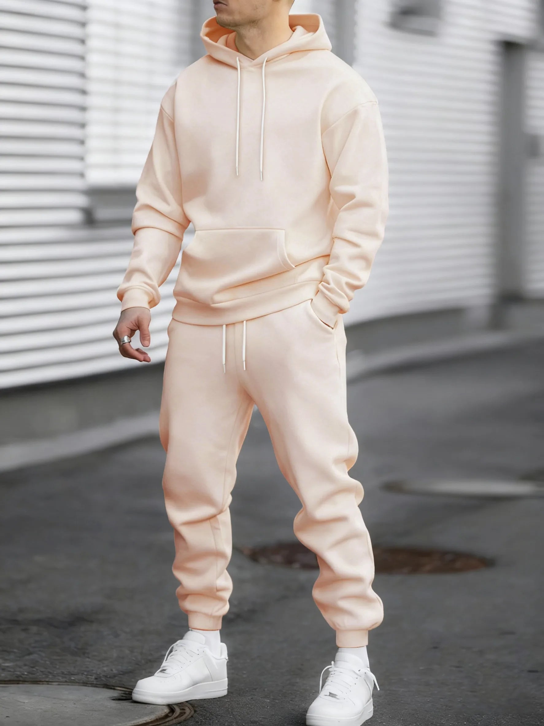 Es un conjunto de dos piezas compuesto por una sudadera con capucha y pantalones deportivos.